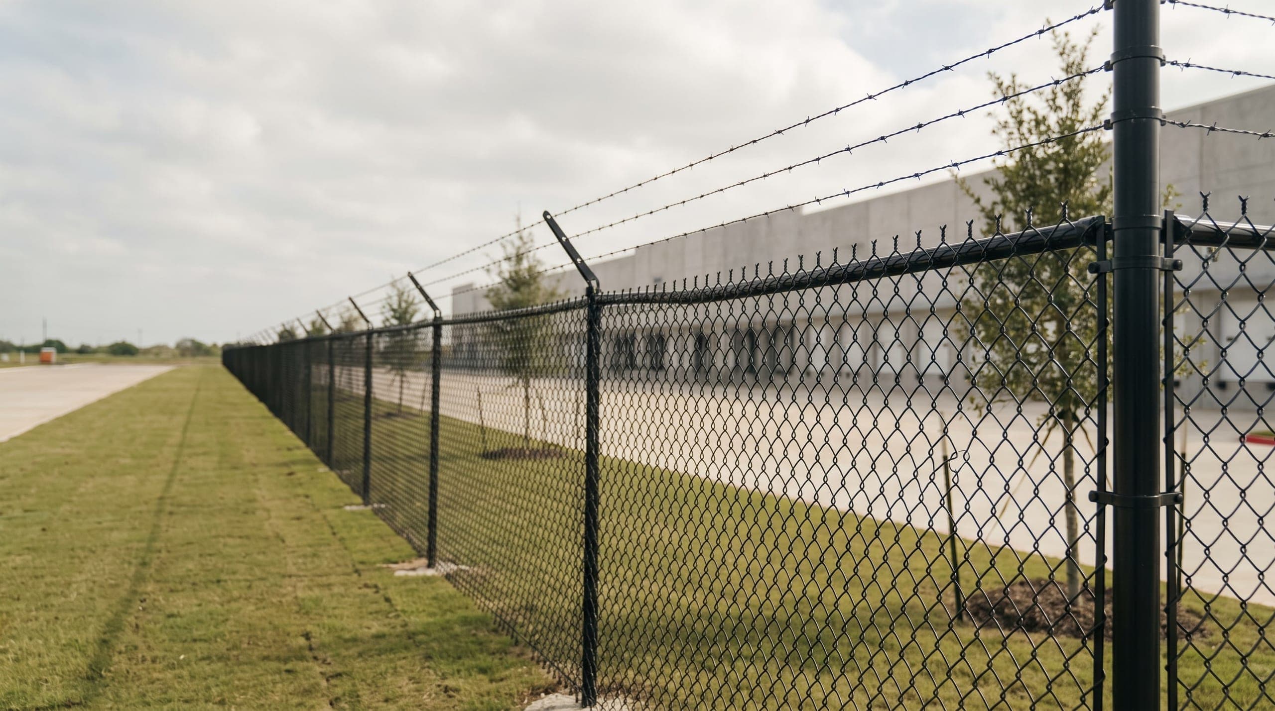 A long commercial security fence line on a Texas site, built by Johnson Services Company.
