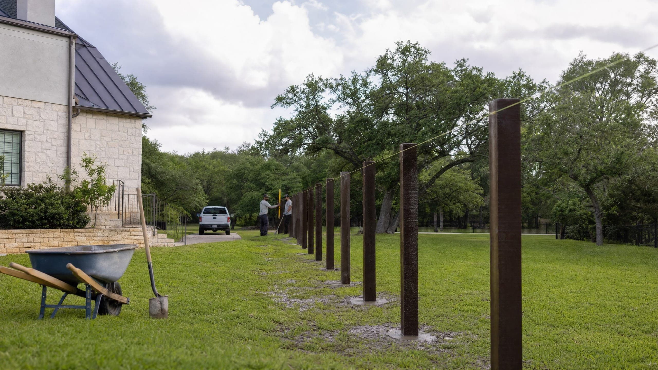 New posts set in concrete along a cleared line, a string pulled between them