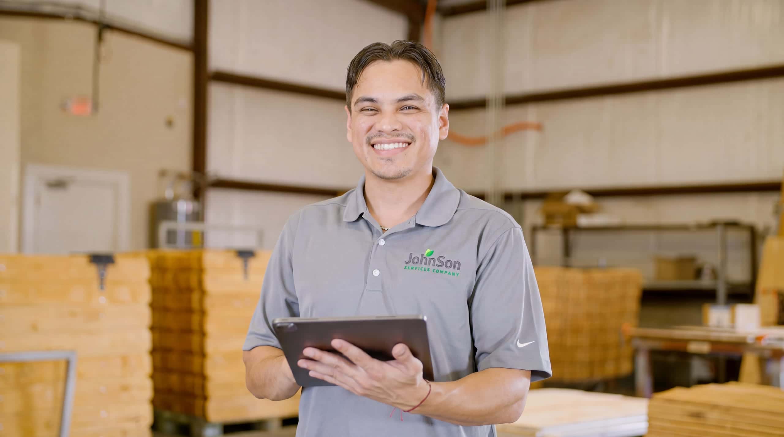 A Johnson salesperson with the measured quote on a tablet, standing where the fence will go