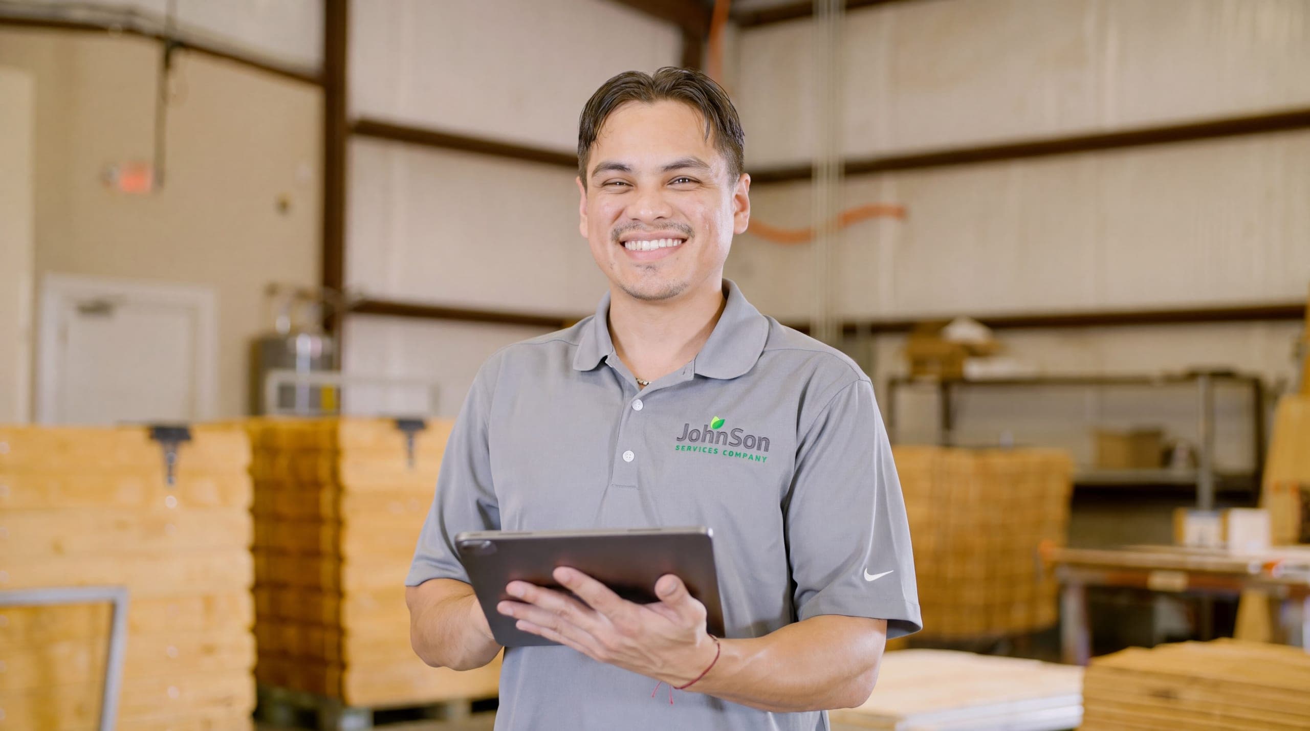 A Johnson salesperson with the measured quote on a tablet, standing where the fence will go